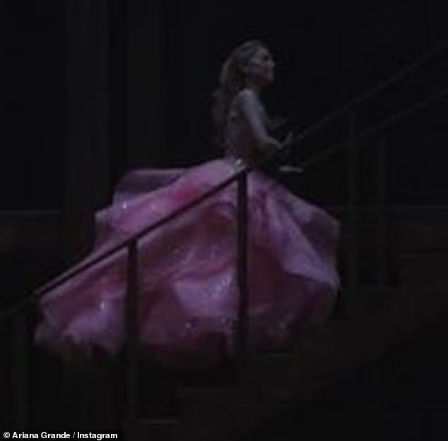 نظرة خاطفة شريرة التسلل!  نشرت أريانا غراندي صورة لشخصيتها ، الساحرة الطيبة غليندا ، وهي ترتدي ثوبًا ورديًا بينما كانت تشق طريقها صعودًا على درج طويل