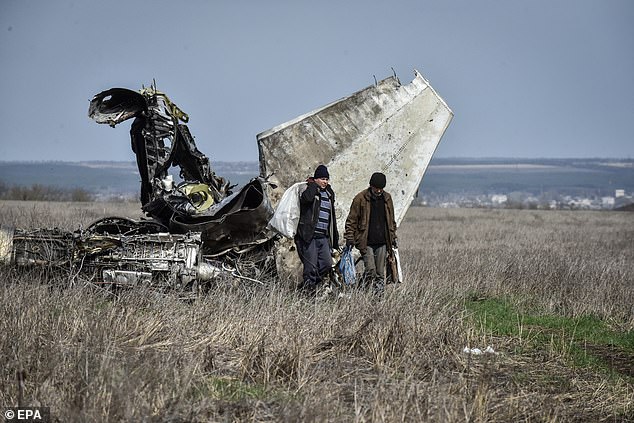 سكان يجمعون المعادن من طائرة مقاتلة محطمة في منطقة خاركيف ، أوكرانيا ، 8 أبريل 2023