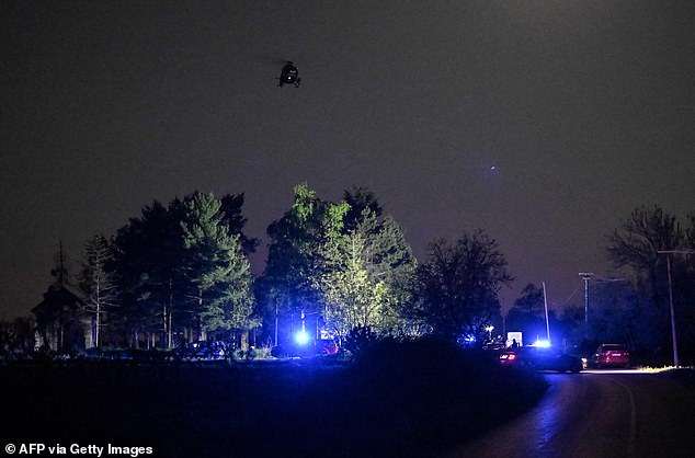طائرة هليكوبتر تحلق بينما يغلق رجال الشرطة الطريق بالقرب من قرية مالو أوراجي ، خارج بلدة ملادينوفاك ، على بعد حوالي 60 كيلومترًا (37 ميلاً) جنوب العاصمة الصربية بلغراد ، في الساعات الأولى من صباح يوم الجمعة.