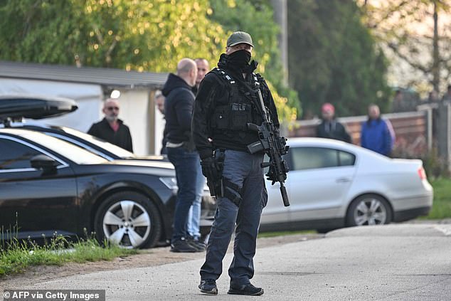 شرطي مسلح شوهد في قرية دوبونا بالقرب من بلدة ملادينوفاك ، على بعد حوالي 60 كيلومترا (37 ميلا) جنوب العاصمة الصربية بلغراد ، يوم الجمعة في أعقاب إطلاق النار الجماعي.