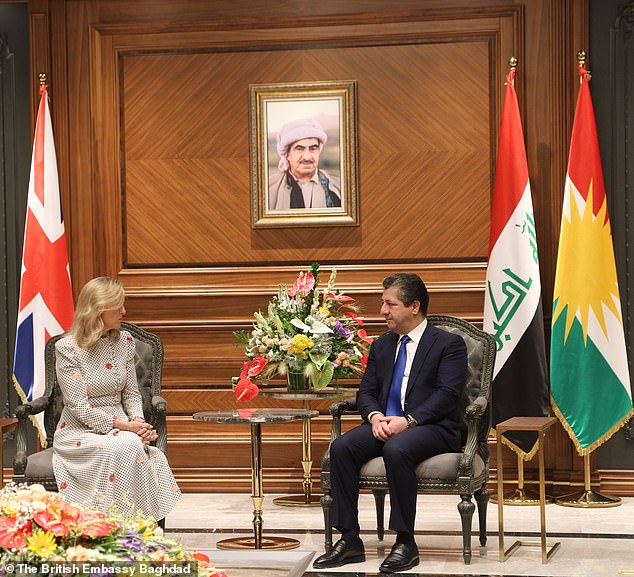 كانت ترتدي فستانًا أبيض بأكمام طويلة بنمط منقطة سوداء حيث تم تصويرها وهي تستمع باهتمام إلى رئيس وزراء إقليم كردستان العراق مسرور بارزاني.