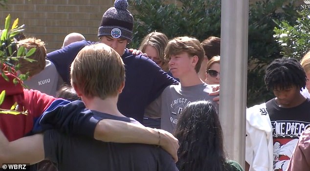يصلي أصدقاؤه في المدرسة في دائرة معًا بعد المأساة