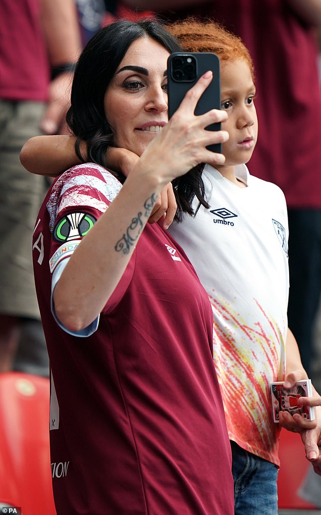 شوهدت لورا مارشيتي ، 41 عاما ، زوجة المدافع أنجيلو أوجبونا ، وهي تلتقط صورا مع ابنها