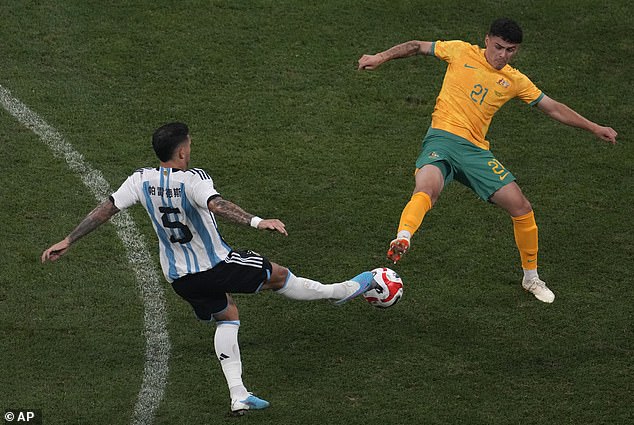 أليكس روبرتسون (يمين) يتنافس على الكرة ضد لياندرو باراديس الأرجنتيني خلال مباراة ودية ليلة الخميس في بكين.