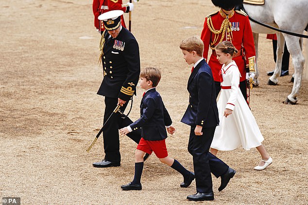يقود الأمير لويس أشقائه الأكبر سناً ، الأمير جورج والأميرة شارلوت أثناء سيرهم على طول موكب هورس جاردز خلال الحفل