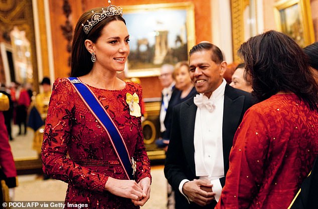 ملكة ملكية تتحدث إلى ضيوف قصر باكنغهام في عام 2022. إنها ترتدي تاج زهرة اللوتس الذي غالبًا ما ترتديه الملكة الأم
