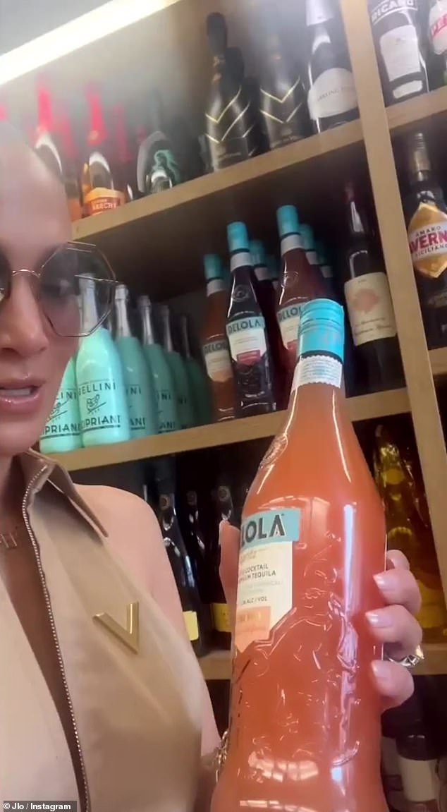 وقت العرض الترويجي: واصلت JLo تسجيل نفسها داخل المتجر حيث التقطت زجاجة من مشروبها الخاص Delola