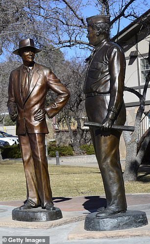 تمثالان من البرونز للدكتور ج. روبرت أوبنهايمر والجنرال ليزلي غروفز يقفان في حديقة في المدينة