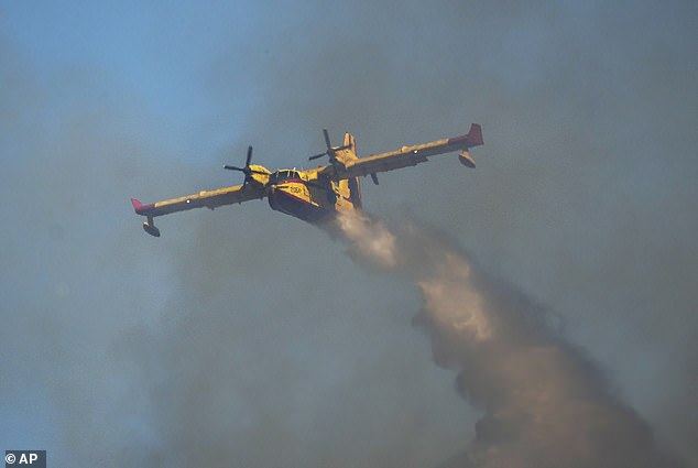 طائرة تابعة لكنداير تسقط المياه فوق حريق هائل في قرية فاتي ، في جزيرة رودس في بحر إيجة ، جنوب شرق اليونان ، يوم الثلاثاء 25 يوليو.