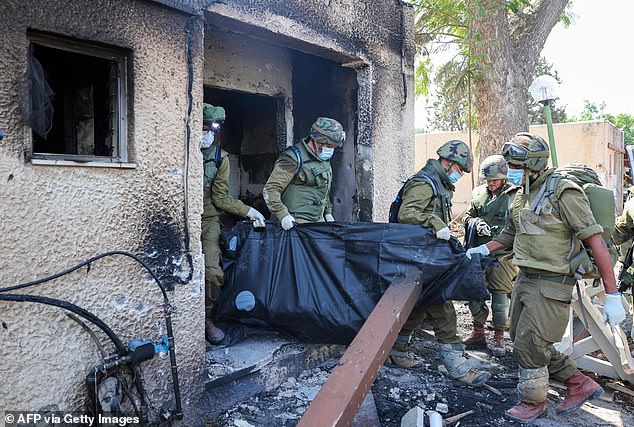 جنود ينتشلون جثث الضحايا الذين قتلوا خلال هجوم نفذته حركة حماس في كفار عزة، يوم الثلاثاء
