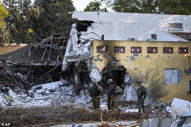 جنود إسرائيليون يسيرون بجوار المنازل التي دمرها مسلحو حماس في كيبوتس بئيري، إسرائيل، السبت 14 أكتوبر 2023.