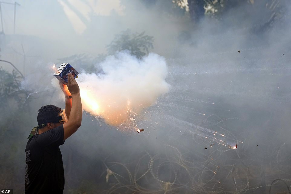 متظاهر يطلق الألعاب النارية على شرطة مكافحة الشغب خلال مظاهرة تضامنا مع الشعب الفلسطيني في غزة بالقرب من السفارة الأمريكية في عوكر – إحدى الضواحي الشمالية لبيروت ، لبنان ، الأربعاء 18 أكتوبر 2023
