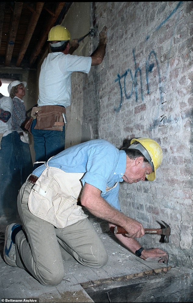 يستخدم كارتر مطرقة وهو يساعد في إعادة تأهيل مساكن الأحياء الفقيرة في الشارع السادس في نيويورك كجزء من مشروع الكنيسة في عام 1984