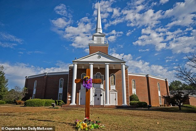 ترك المصلون المنكوبون زهورًا عند سفح صليب أمام الكنيسة المعمدانية الأولى في مدينة فينيكس بولاية ألاباما، يوم الأحد.