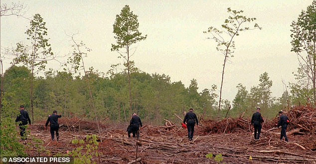 شوهد محققو شرطة ولاية فرجينيا وهم يفتشون المنطقة القريبة من المكان الذي تم العثور فيه على جثة أليسيا شوالتر رينولدز خارج كولبيبر، فيرجينيا في مايو 1996.