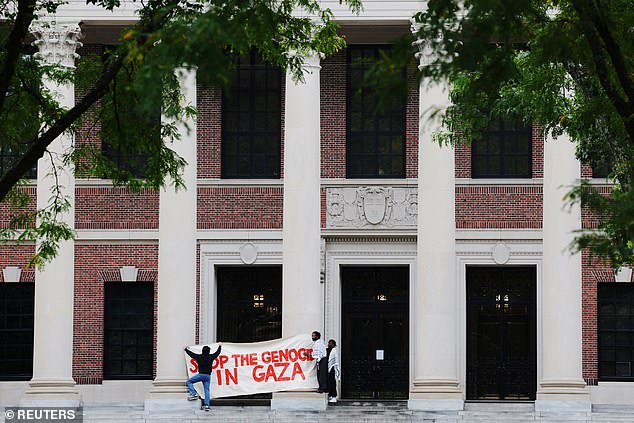 متظاهرون مناصرون لفلسطين في جامعة هارفارد يعلقون لافتة كتب عليها 