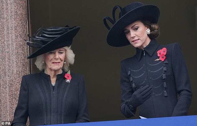 وقف أفراد العائلة المالكة معًا على شرفة في وزارة الخارجية والكومنولث والتنمية أثناء الخدمة في النصب التذكاري، في وايتهول، لندن.