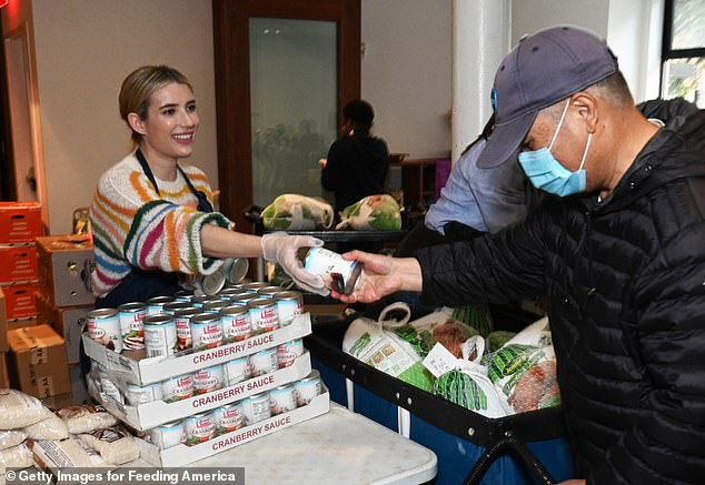 أيدي المساعدة: حافظت الشبة الأمريكية البالغة من العمر 32 عامًا على ابتسامة عريضة على وجهها أثناء مساعدتها في توزيع الطعام على المحتاجين في الجمعية الخيرية السنوية للمنظمة