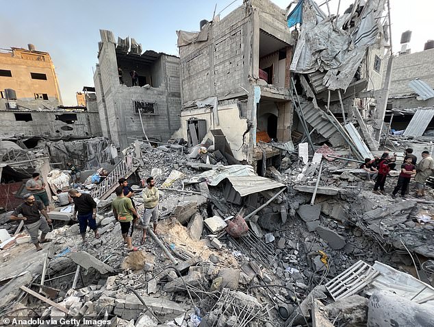 تقوم فرق الدفاع المدني، إلى جانب السكان المحليين، بعملية بحث وإنقاذ وسط أنقاض المباني السكنية بعد أن أصابت الهجمات الإسرائيلية المباني السكنية في مخيم جباليا في جباليا، غزة، في 18 نوفمبر/تشرين الثاني 2023.