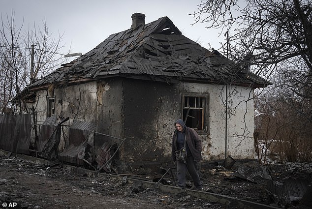 أحد السكان المحليين يمر بالقرب من منزل خاص تضرر في الهجوم الصاروخي الروسي في كييف، أوكرانيا، يوم الاثنين
