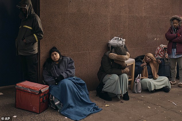 مهاجرون يصطفون في البرد أثناء بحثهم عن مأوى خارج مركز مساعدة المهاجرين في نيويورك