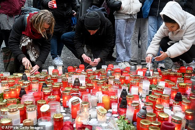 شباب يضيئون الشموع في نصب تذكاري مؤقت للضحايا خارج جامعة تشارلز في وسط براغ يوم الجمعة