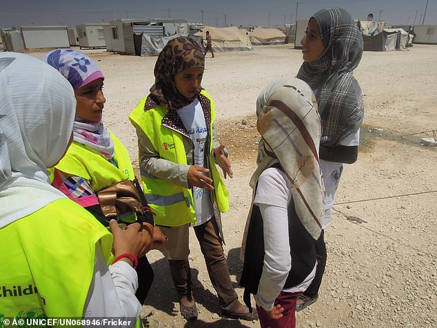 تظهر في الصورة مزون وهي تتحدث مع فتيات أخريات في مخيم الزعتري للاجئين حول فرص التعلم كجزء من حملة العودة إلى المدرسة.