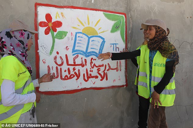 أثناء إقامتها في مخيم الزعتري للاجئين، تشير مزون البالغة من العمر 14 عاماً إلى لافتة تسلط الضوء على أهمية المدرسة والتعلم