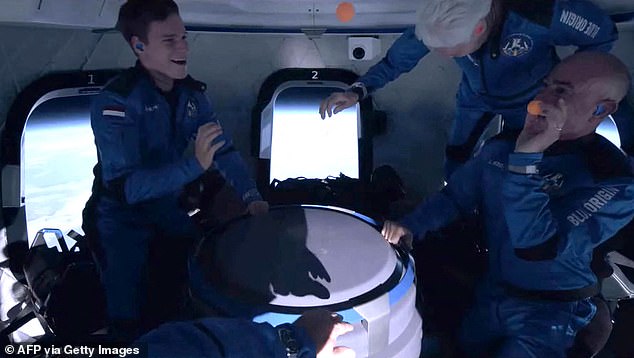 مارك بيزوس، على اليمين، يرمي كرات بينج بونج مع زميله أوليفر دايمن، على اليسار، خلال رحلة الفضاء في يوليو 2021 حول أول مهمة مأهولة لشركة Blue Origin