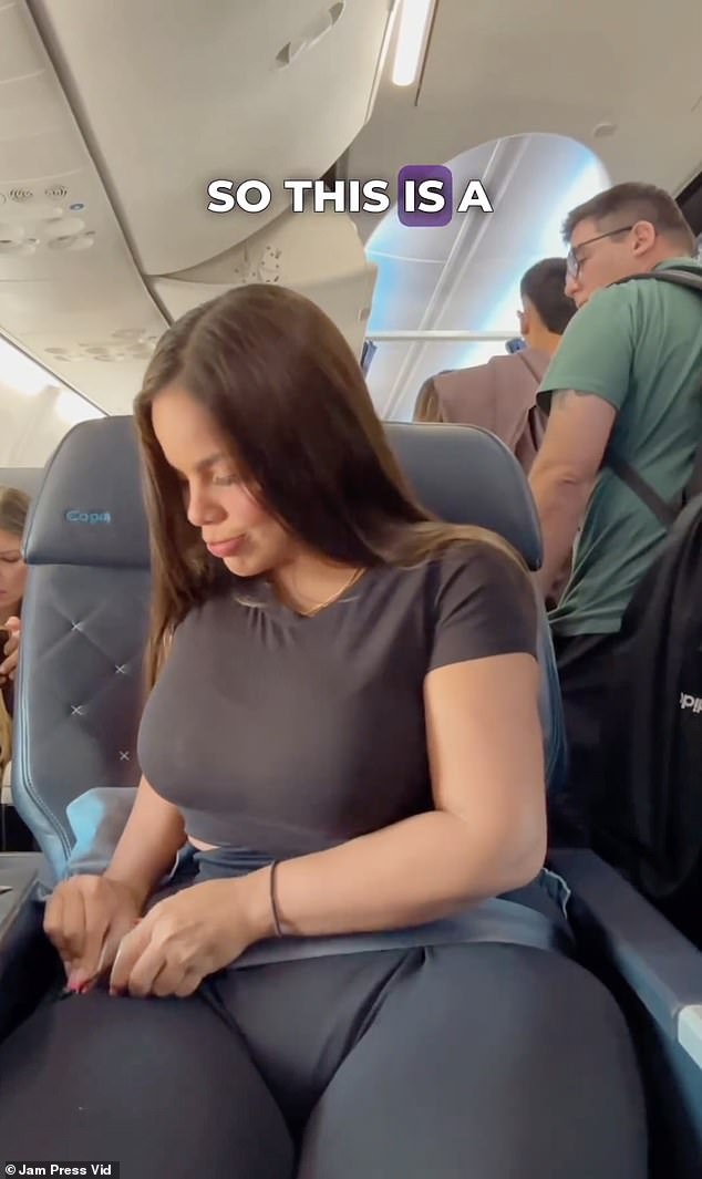 يُظهر المقطع المرأة ذات الحجم الزائد البالغة من العمر 26 عامًا وهي تتجهم على متن الطائرة وهي تكافح من أجل وضع حزام الأمان.