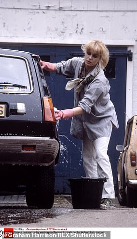 جوانا لوملي تغسل سيارتها رينو 5 خارج شقتها في هولاند بارك، لندن.