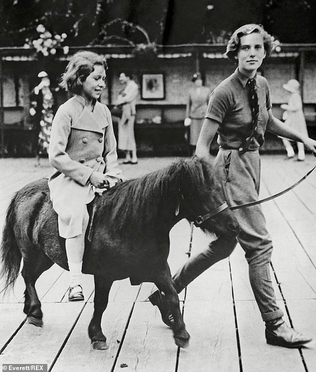 سيدة في الانتظار تأخذ الأميرة إليزابيث وشقيقتها الصغرى الأميرة مارغريت في زيارة إلى ركن الحيوانات الأليفة في حديقة حيوان لندن في عام 1937