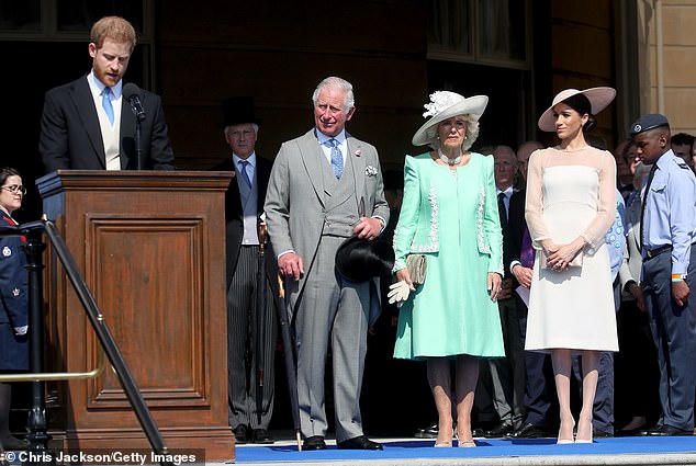 الأمير هاري يتحدث بينما يشاهد تشارلز وكاميلا وميغان أثناء حضورهم الاحتفال بعيد ميلاد أمير ويلز السبعين الذي أقيم في قصر باكنغهام في مايو 2018