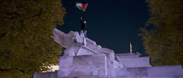 متظاهر مؤيد لفلسطين على قمة النصب التذكاري للمدفعية الملكية في حديقة هايد بارك في لندن