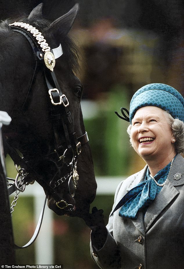 الملكة الراحلة إليزابيث تبتسم وهي تستعرض القوات التي تمتطي الخيول في معرض وندسور الملكي للخيول