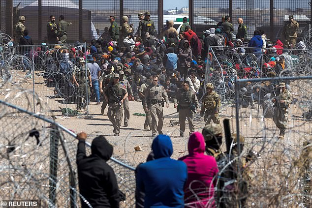 مهاجرون غير شرعيين يخترقون الأسلاك الشائكة أثناء دخولهم بالقوة إلى الولايات المتحدة عبر الحدود الجنوبية في 21 مارس 2024