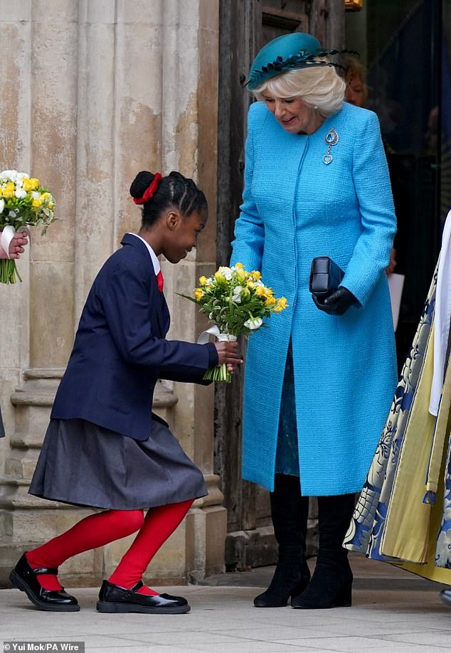 قدمت الملكة كاميلا الزهور من قبل أطفال المدارس أثناء مغادرتها خدمة يوم الكومنولث السنوية في كنيسة وستمنستر