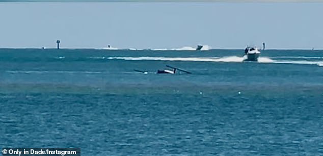 ومن الشاطئ، شاهد الناس وحدة تابعة للشرطة البحرية وهي تقوم بعملية إنقاذ سريعة؛  في الصورة: المروحية الغارقة تتمايل في الماء وقوارب الإنقاذ تهرع لمساعدة الطيار