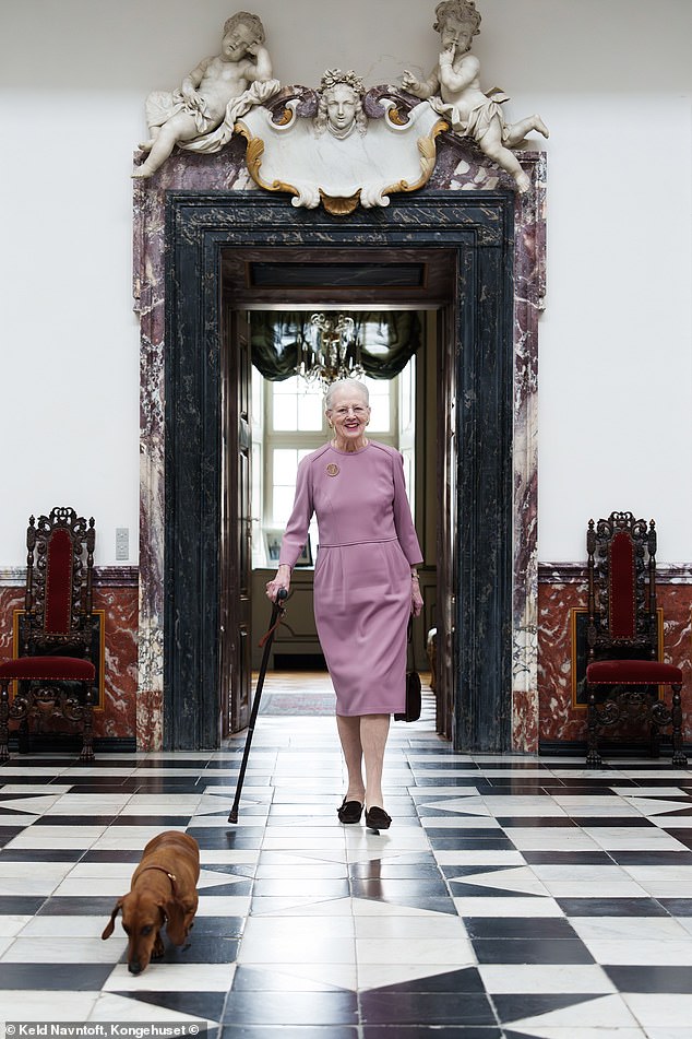 تُظهر اللقطة الثانية الملكة السابقة وهي تسير على طول الأرضية المبلطة أحادية اللون في قلعة فريدنسبورج، إلى جانب كلبتها تيليا.