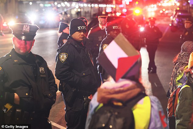 ضباط شرطة نيويورك يقفون على أهبة الاستعداد بينما يتجمع الناس للاحتجاج على حظر طلاب من أجل العدالة في فلسطين (SJP) والصوت اليهودي من أجل السلام (JVP) في جامعة كولومبيا
