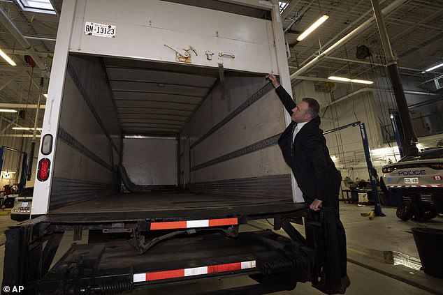 فتح ضباط الشرطة الجزء الخلفي من الشاحنة التي استخدمها اللصوص لسرقة البضائع خلال مؤتمر صحفي في مطار بيرسون الدولي، في برامبتون، أونتاريو، يوم الأربعاء.