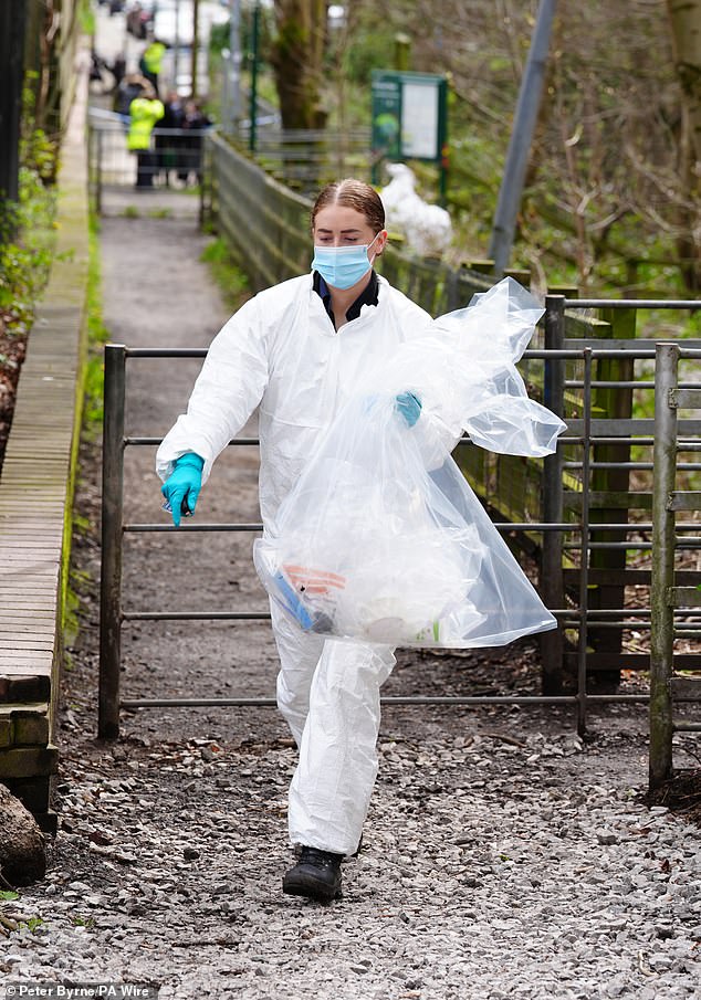 أحد ضباط الطب الشرعي يمشي بحقيبة بلاستيكية مليئة بعدد من العناصر المتنوعة يوم الجمعة 5 أبريل