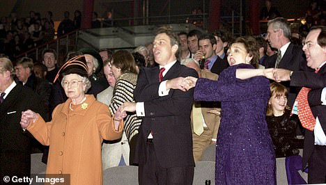 الملكة إليزابيث الثانية ورئيس الوزراء البريطاني توني بلير وزوجته شيري بلير يتكاتفون في Auld Lang Syne في عام 1999