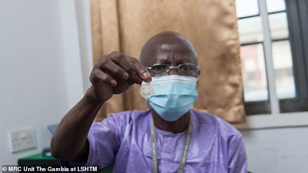 تشير النتائج إلى أن اللاصقات لا تحتاج إلى أن يتم إدارتها من قبل طاقم طبي مدرب، مما قد يؤدي إلى تحمل المسؤولية بعيدًا عن العمليات الجراحية العامة.  في الصورة، أحد العاملين في مجال الرعاية الصحية في غامبيا يحمل رقعة ميكروأري من النوع المستخدم في الدراسة