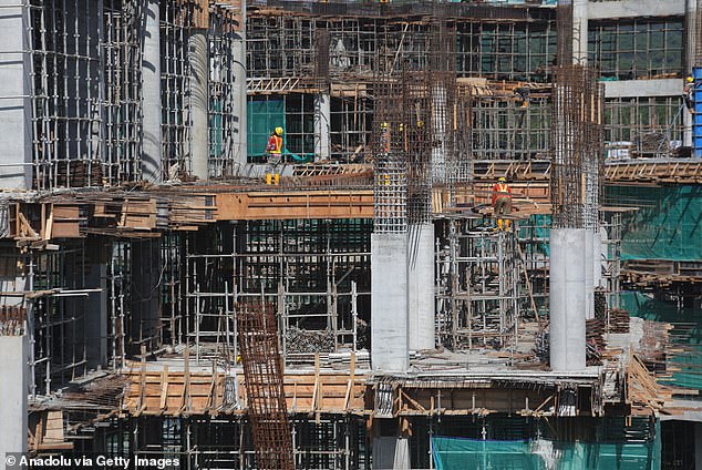 العمال يكملون بناء مبنى متعدد الطوابق في نوسانتارا