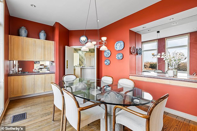 تتميز منطقة تناول الطعام بأرضية خشبية مما يضيف لمسة من الأناقة إلى الغرفة ذات الجدران الحمراء