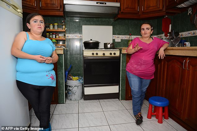 ماريتزا (يسار) ولوغارتدا فالاريزو (يمين)، في مطبخهما في كيتو، الإكوادور، في عام 2014. الأختان فالاريزو مريضتان لدى مؤلف الدراسة المشارك خايمي جيفارا أغيري، الذي درس متلازمة لارون لأكثر من عقدين من الزمن.