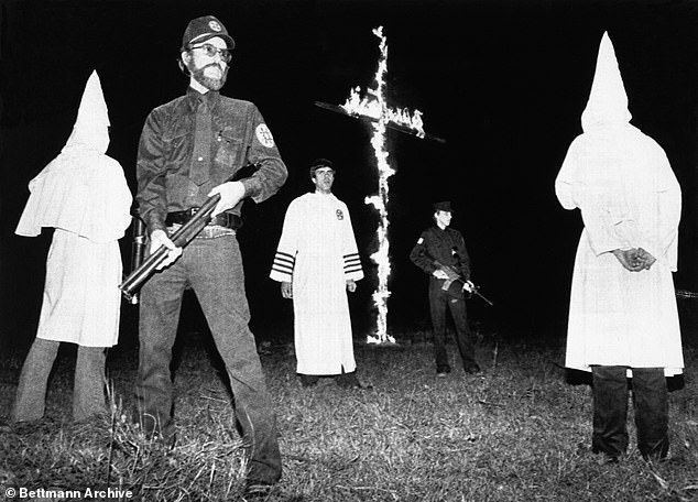 دون بلاك (في الوسط، باللون الأبيض) محاط بحراس مسلحين عند ذروة حرق الصليب في مسيرة تجنيد كلان في عام 1982