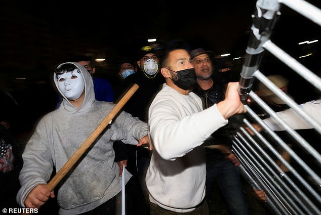 متظاهرون مناهضون يحملون أشياء في مخيم مؤيد للفلسطينيين في حرم جامعة كاليفورنيا، لوس أنجلوس، 1 مايو