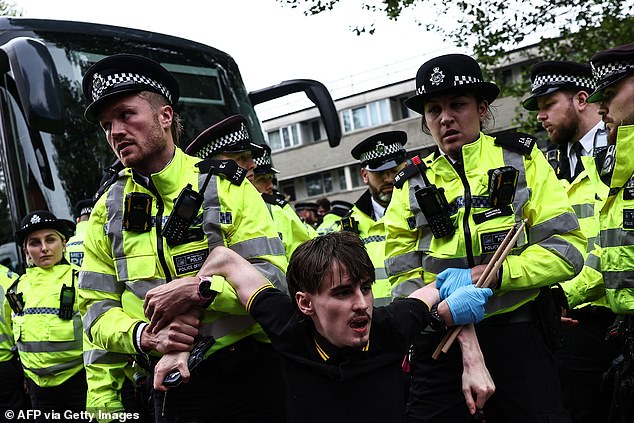 اعتقال أحد المتظاهرين من قبل ضباط الشرطة الذين كانوا يحتجون خارج الفندق في بيكهام